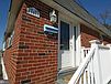 A brick house with a white railing

Description automatically generated
